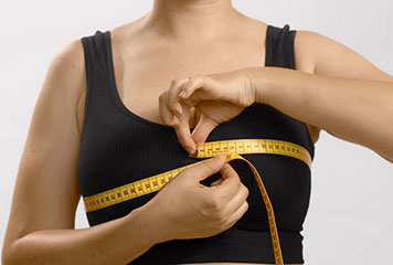women measuring her breast with a metered tape